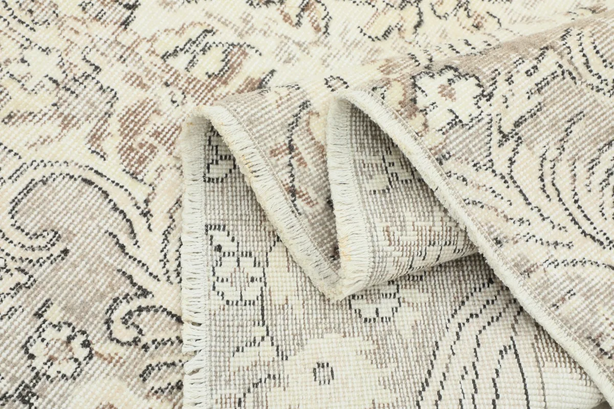 Folded corner of the rug showing the thickness, pile, and hand-knotted construction