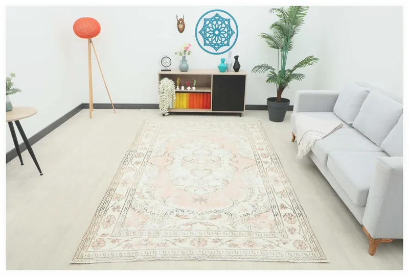 Full top view of the rose and ivory vintage Anatolian area rug with a central medallion design
