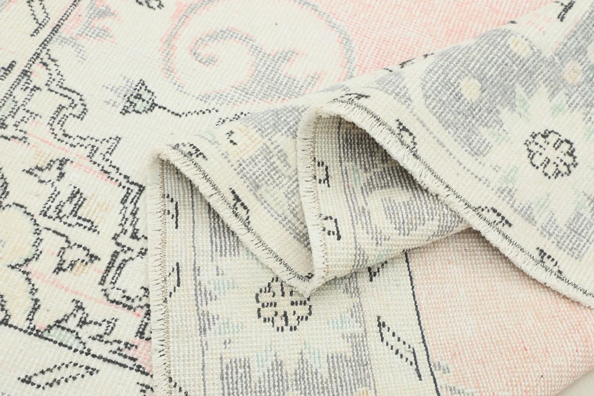 Close-up of the rug's low pile, showing the wool texture and the subtle color variations from its vintage character.