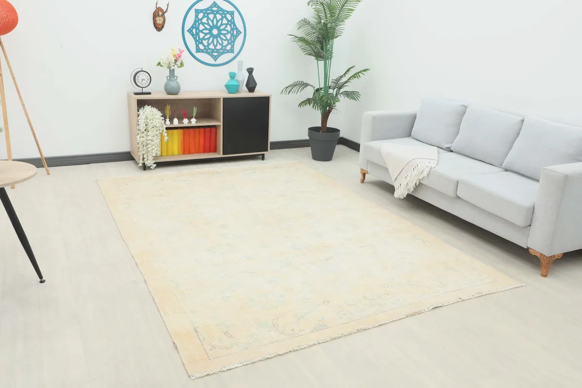 Ivory and blue vintage rug displayed in a living room setting with a light gray sofa and modern decor.