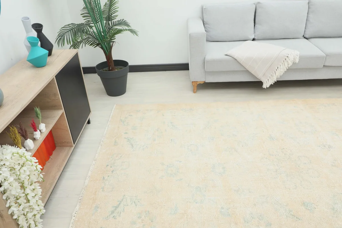 Angle view of the ivory and blue vintage rug in a room, highlighting its size relative to furniture.