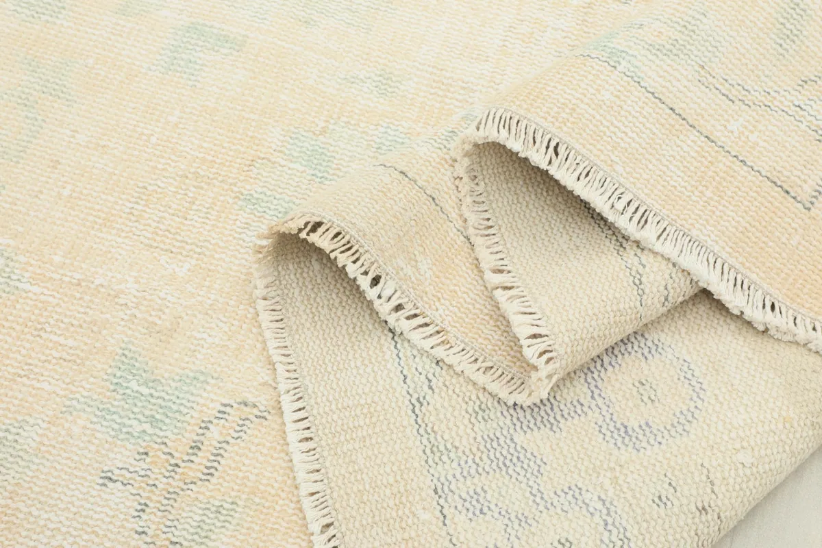 Close-up of the rug's folded edge, showing the thickness of the hand-knotted wool pile.