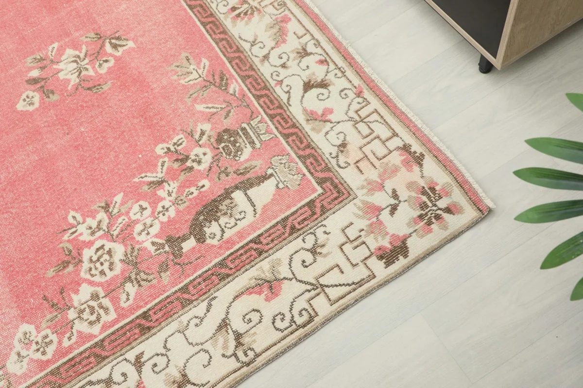 Detail of the rug's corner, showcasing the ivory border and floral designs