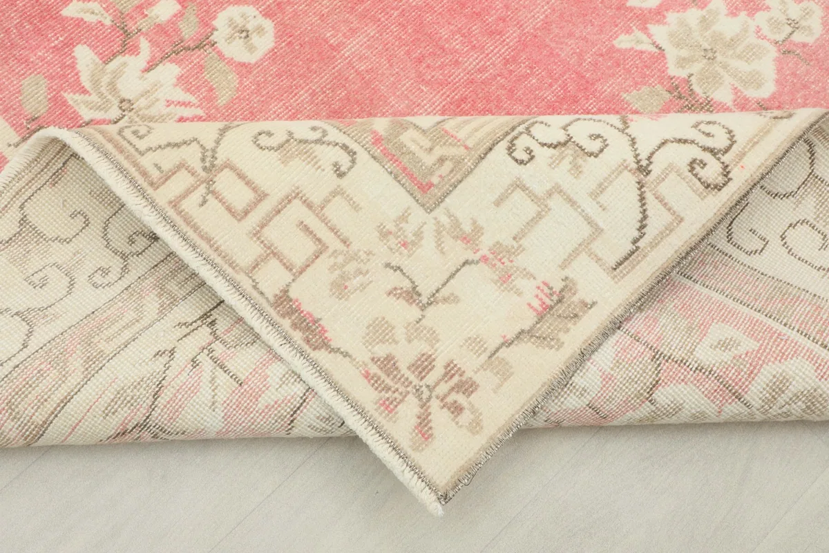 Folded corner of the rug revealing the cotton foundation and hand-knotted back