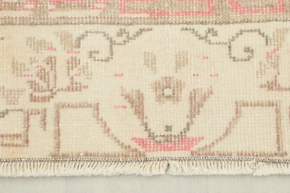 Close-up view of the rug's short fringe and the detailed border pattern