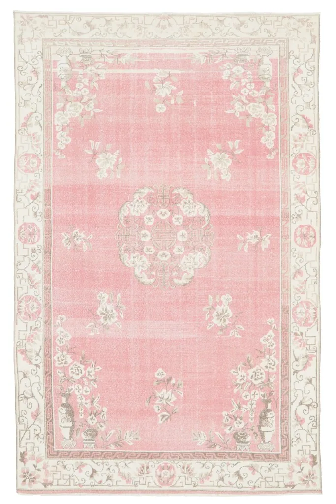 Full overhead view of the vintage pink area rug on a white background