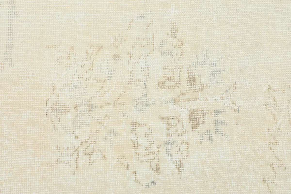 Close-up showing the faded, distressed texture and subtle motifs of the rug's pile