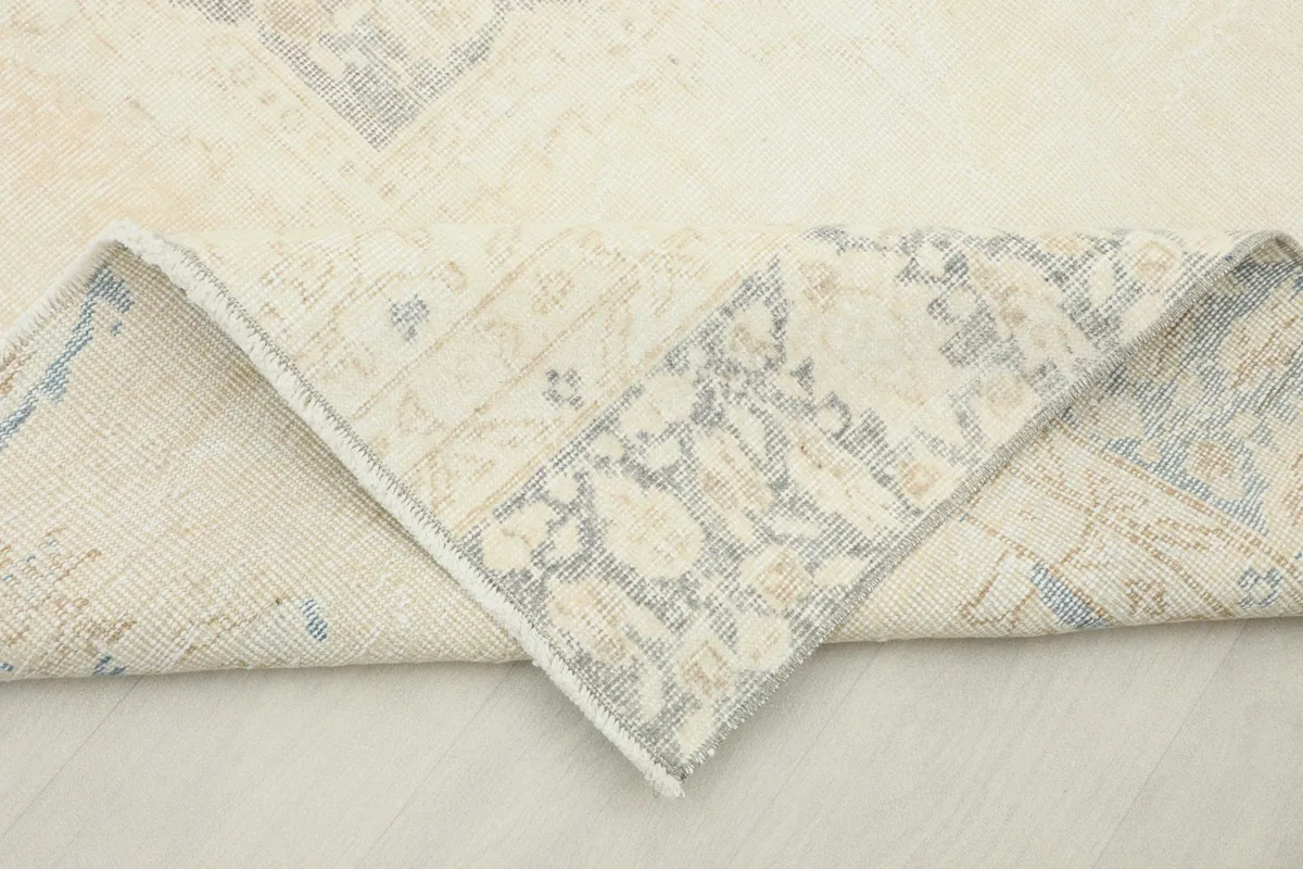 Folded corner of the rug revealing the back of the hand-knotted wool on cotton foundation