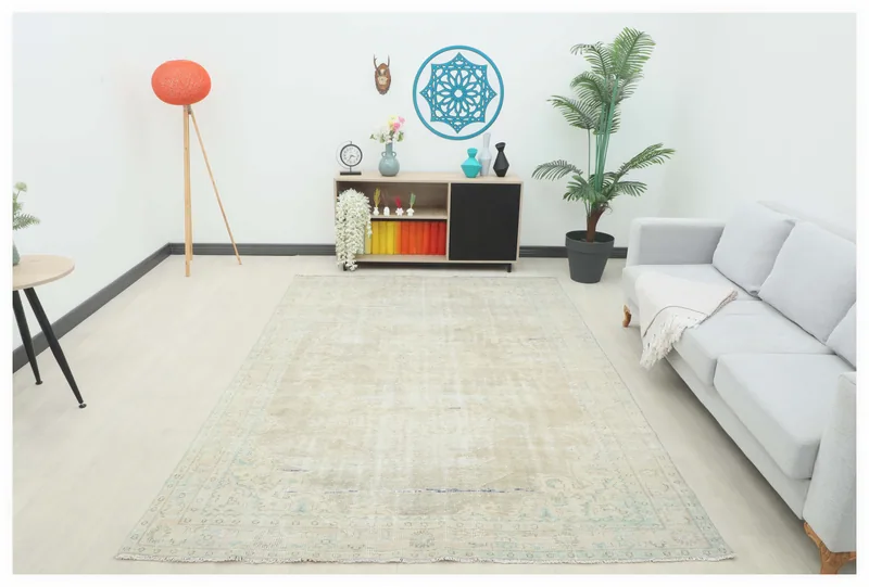 Full overhead view of the beige and blue vintage Anatolian area rug on a white floor in a modern room