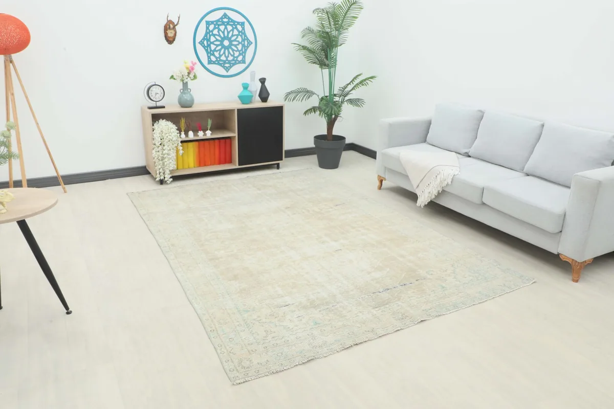 Angle view of the beige vintage rug in a living room setting with a light gray sofa