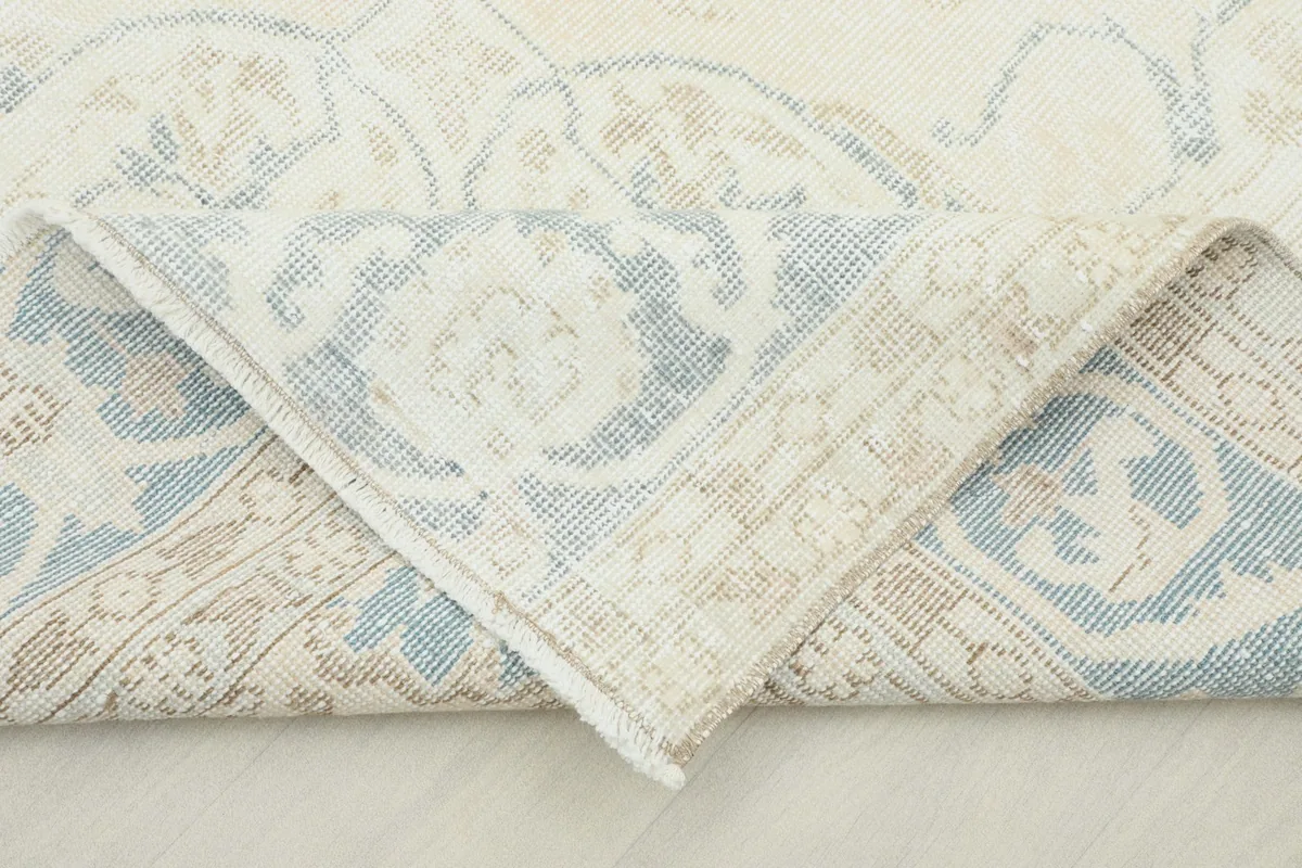Folded corner of the rug revealing the cotton foundation and hand-knotted construction.