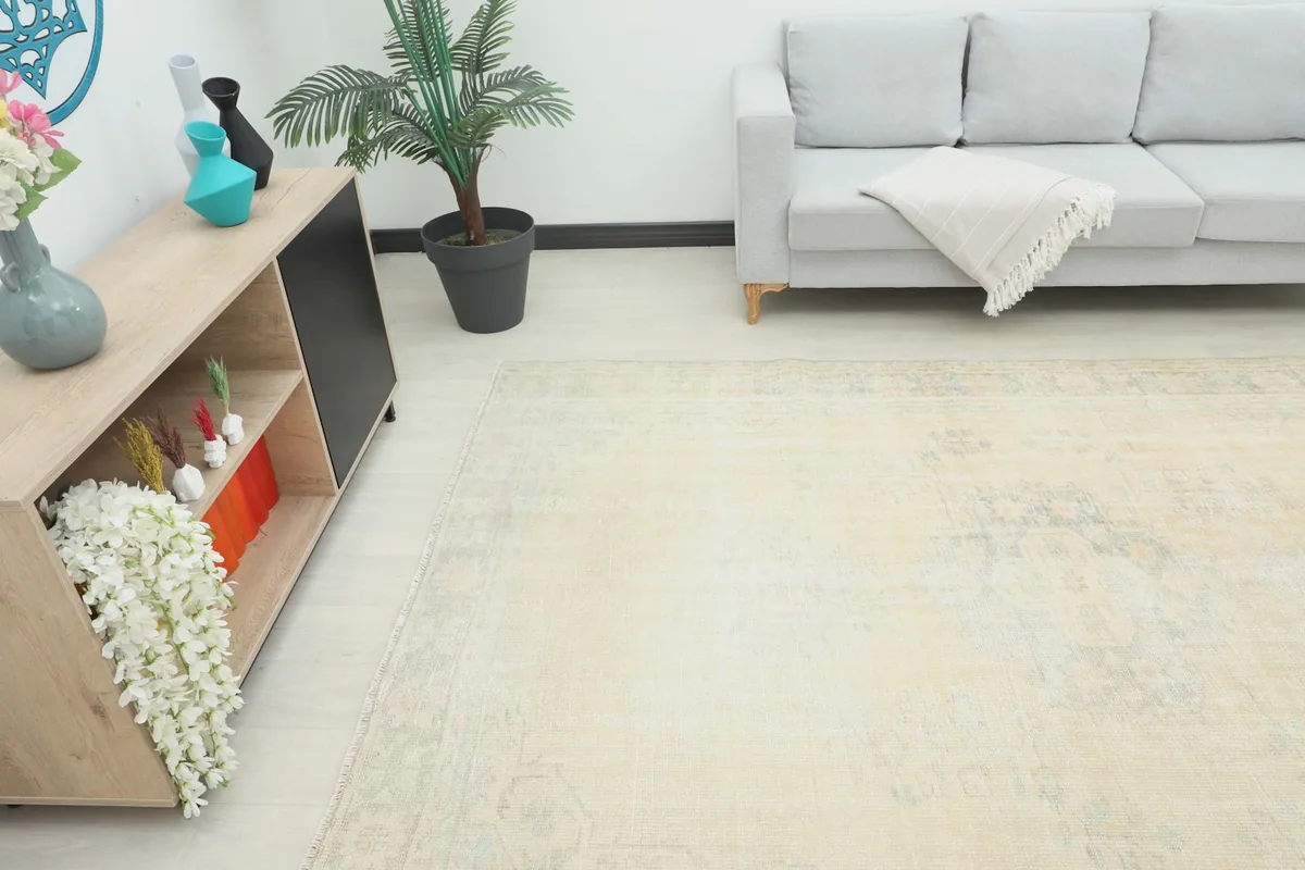Angle view of the ivory rug in a room setting, showing its placement relative to a sofa