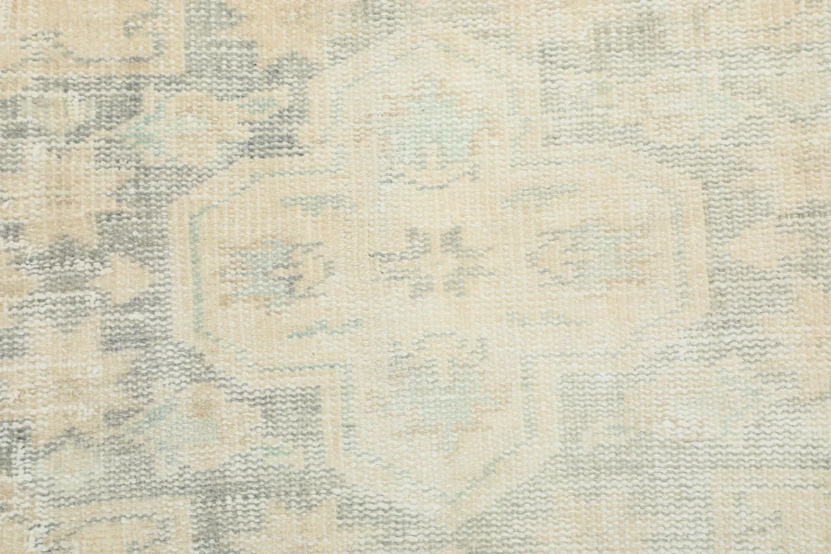 Close-up of the faded geometric patterns and texture of the vintage wool pile