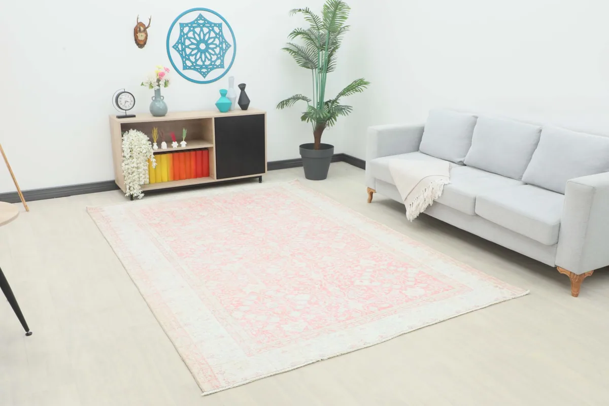 Vintage rose floral rug displayed in a living room setting with a light gray sofa and modern decor.