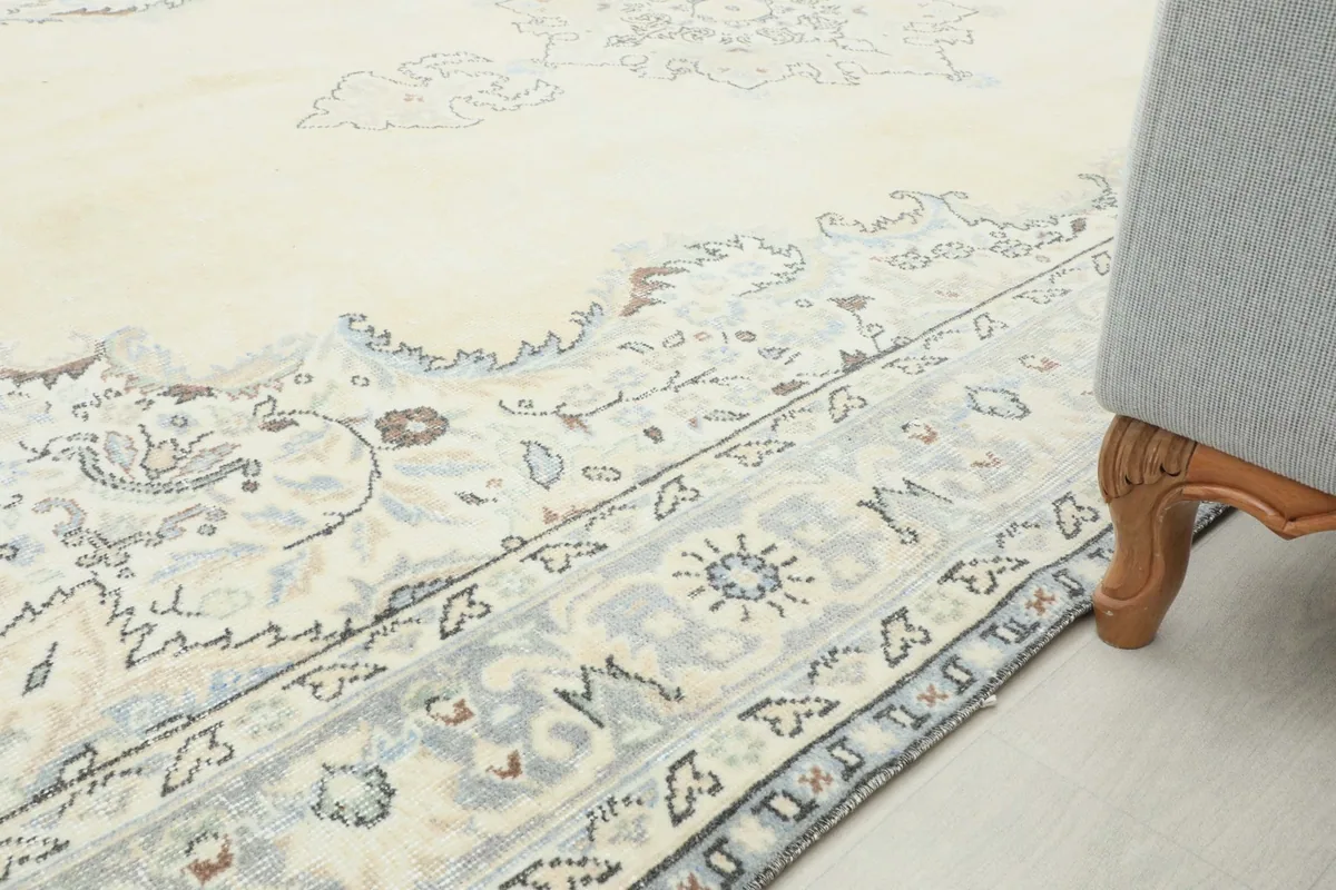 Close-up of the rug's border and a furniture leg, showcasing the blue and gray patterns.