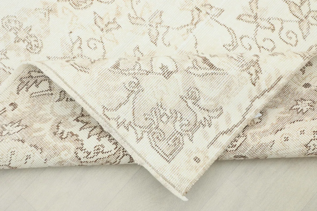 Underside of the corner of the hand-knotted rug, revealing the cotton foundation and knotting.