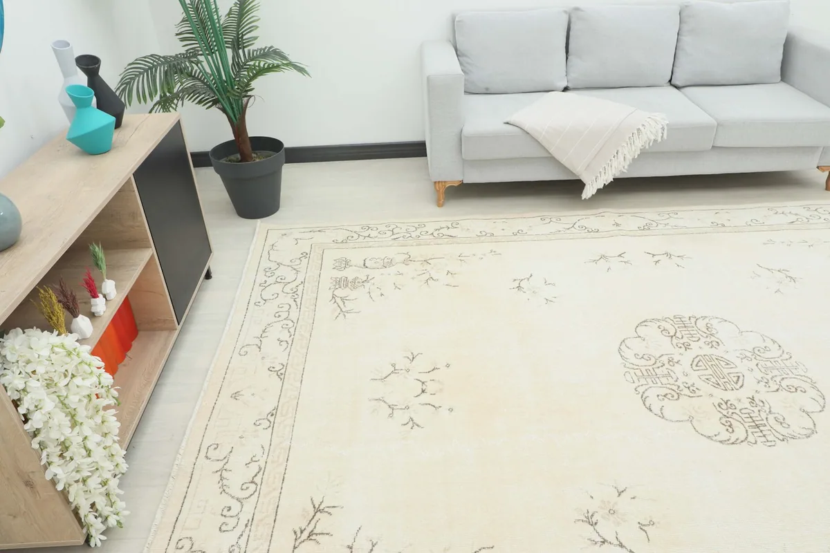 Overhead angle view of the cream vintage rug in a room, showing its scale next to furniture
