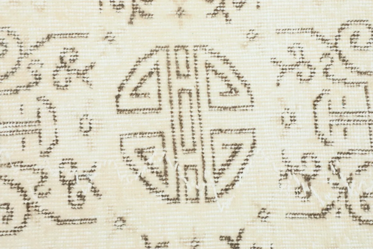 Close-up of the faded brown and charcoal pattern, showing the hand-knotted wool texture