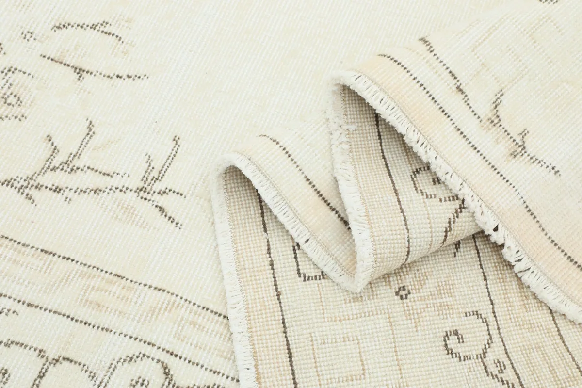 Folded section of the rug, revealing the thickness of the low pile and the consistency of the weave
