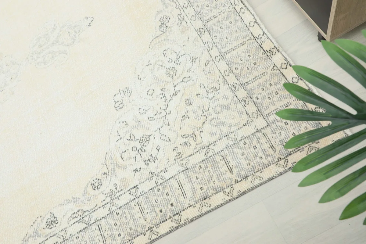 Corner view highlighting the border details and the gentle patina of the vintage wool rug