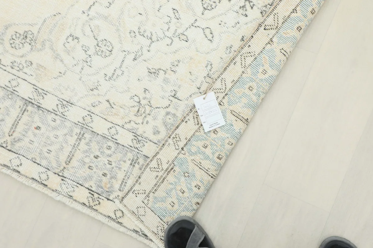 View of the rug's corner with a product tag, showing the back and pile