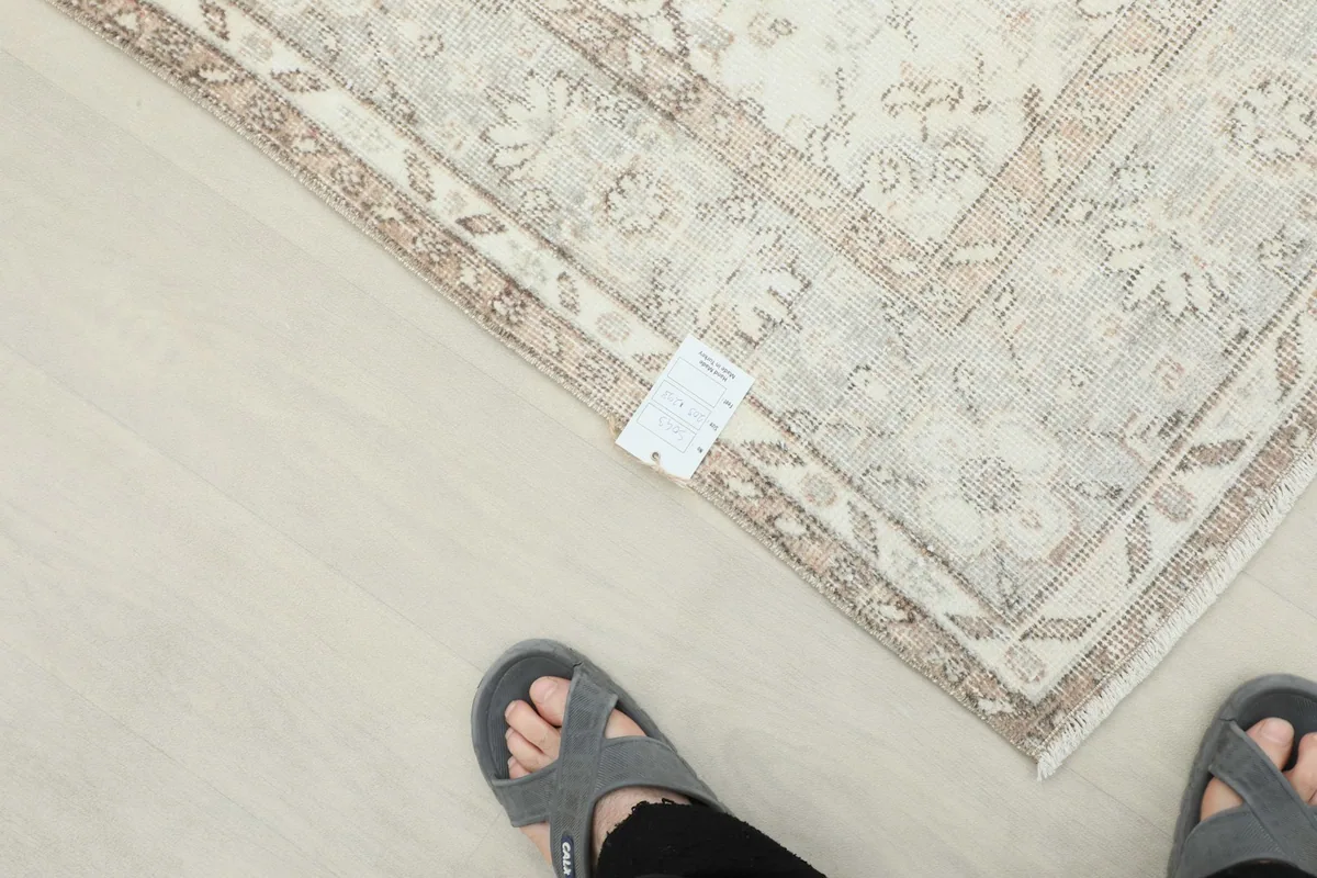 Overhead shot of the rug's corner with a care tag, showing the detailed border and field.
