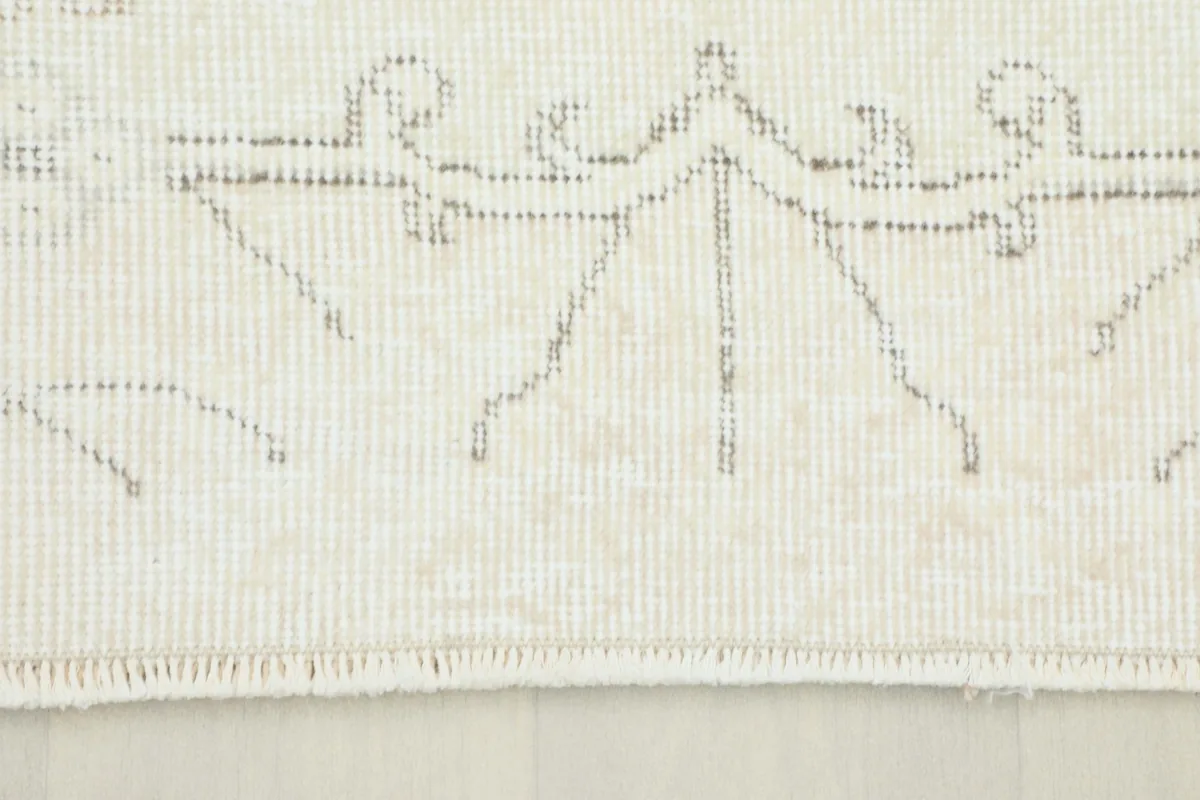 Close-up detail of the rug's short fringe and subtle pattern at one end.