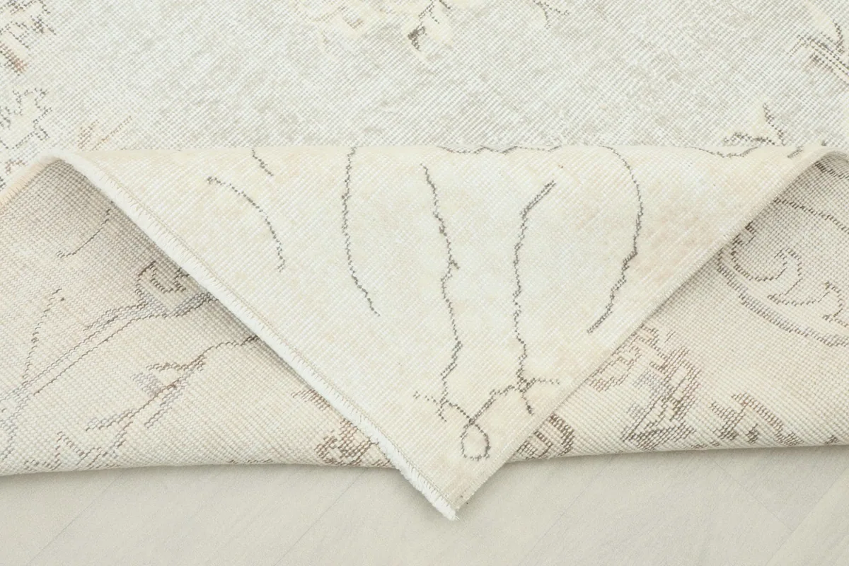 Folded corner of the rug revealing the cotton foundation and hand-knotted construction.