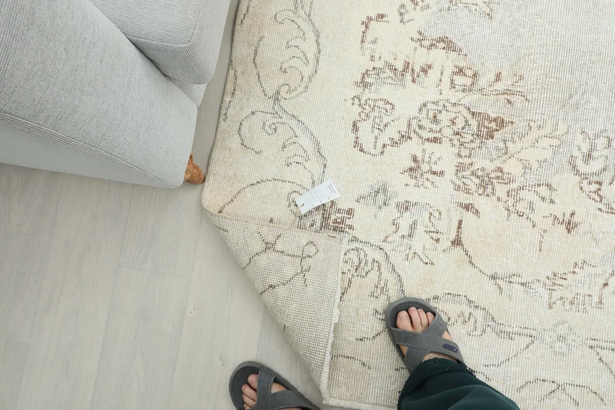 Person's feet on the rug, showing the rug's texture and thickness from a human perspective.