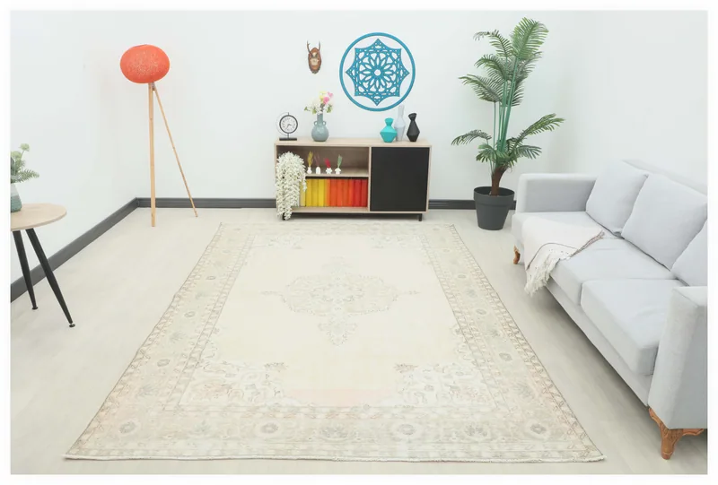 Full overhead view of the cream and beige vintage Anatolian area rug on a white floor