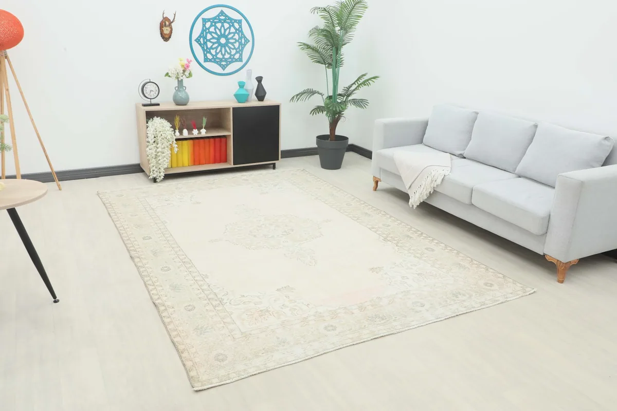 Vintage Anatolian rug in a room setting with a light gray sofa and decorative items
