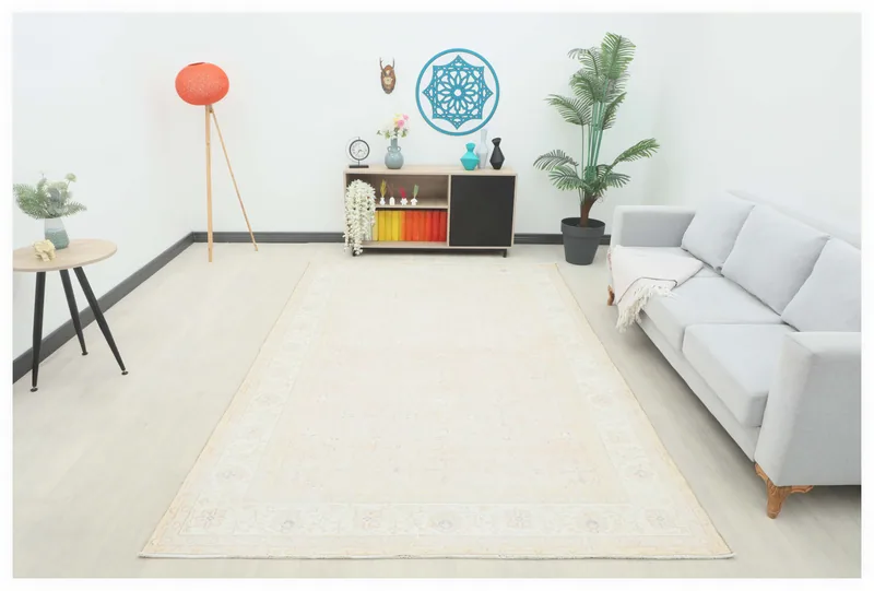 Full top view of a beige vintage Anatolian area rug with subtle floral and geometric patterns