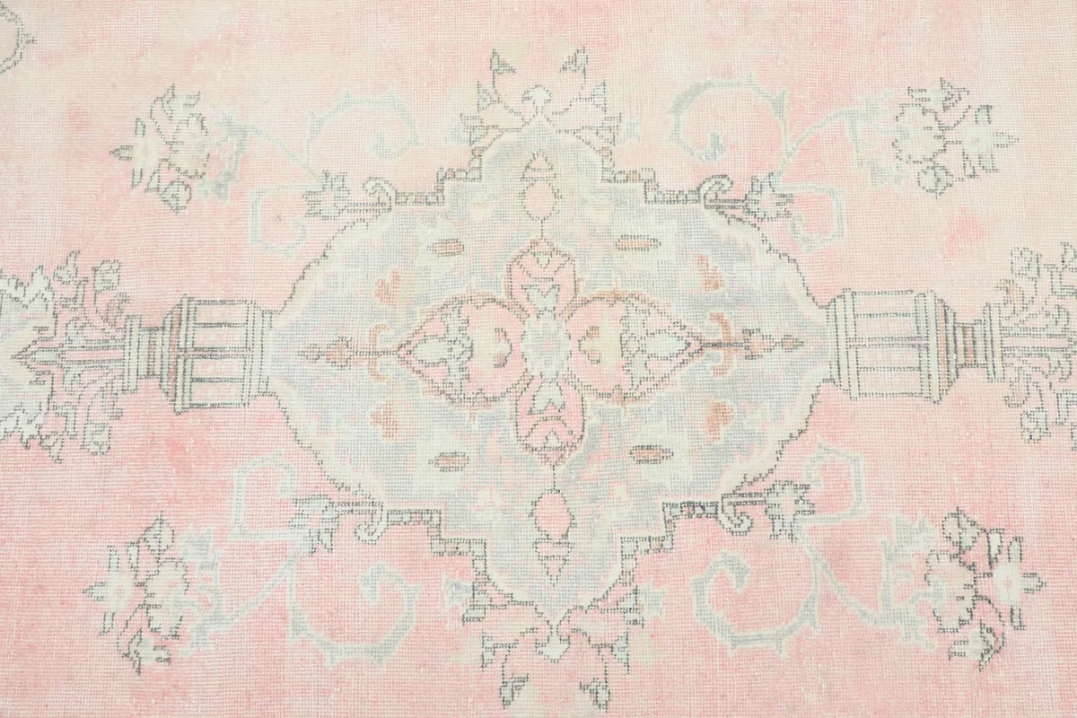 Detailed view of the central medallion design on the rose field of the vintage Anatolian rug