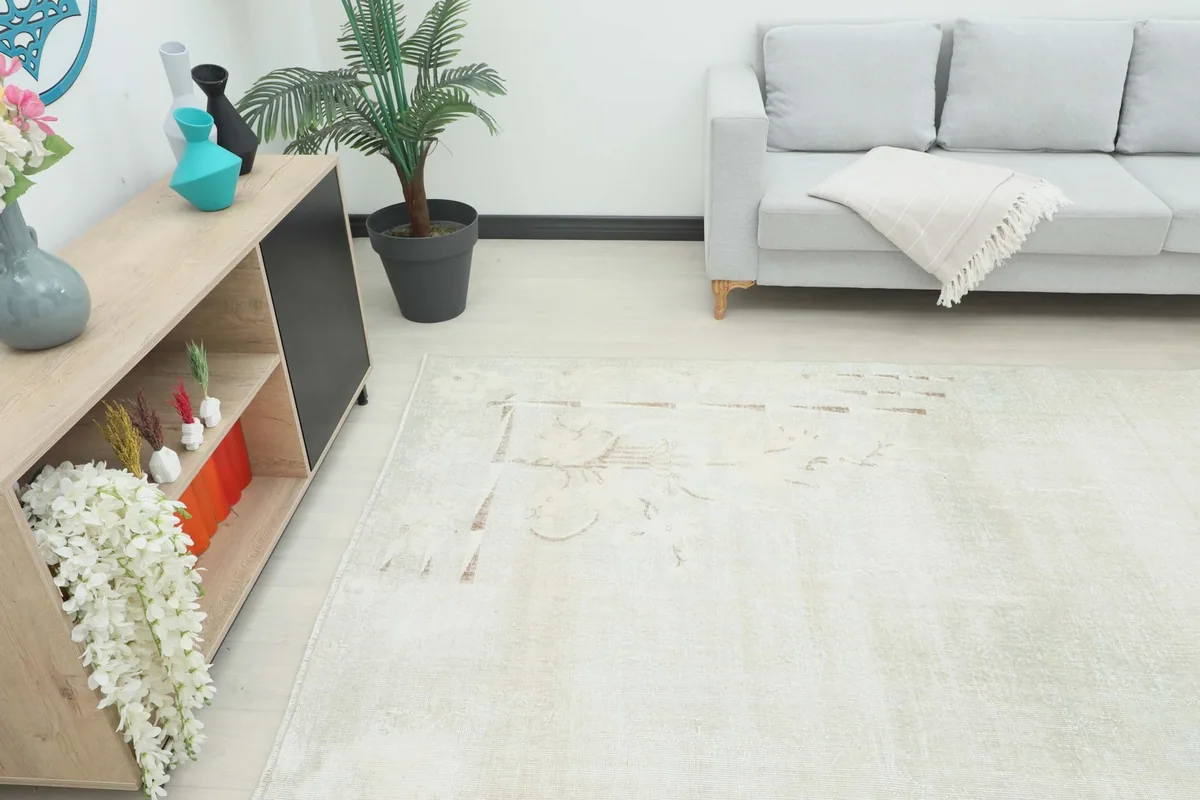 Overhead shot of the beige vintage rug in a living space, showing its placement relative to furniture.