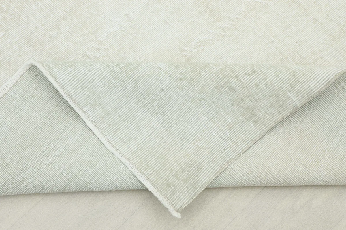 Folded corner revealing the back of the hand-knotted wool pile on cotton foundation.