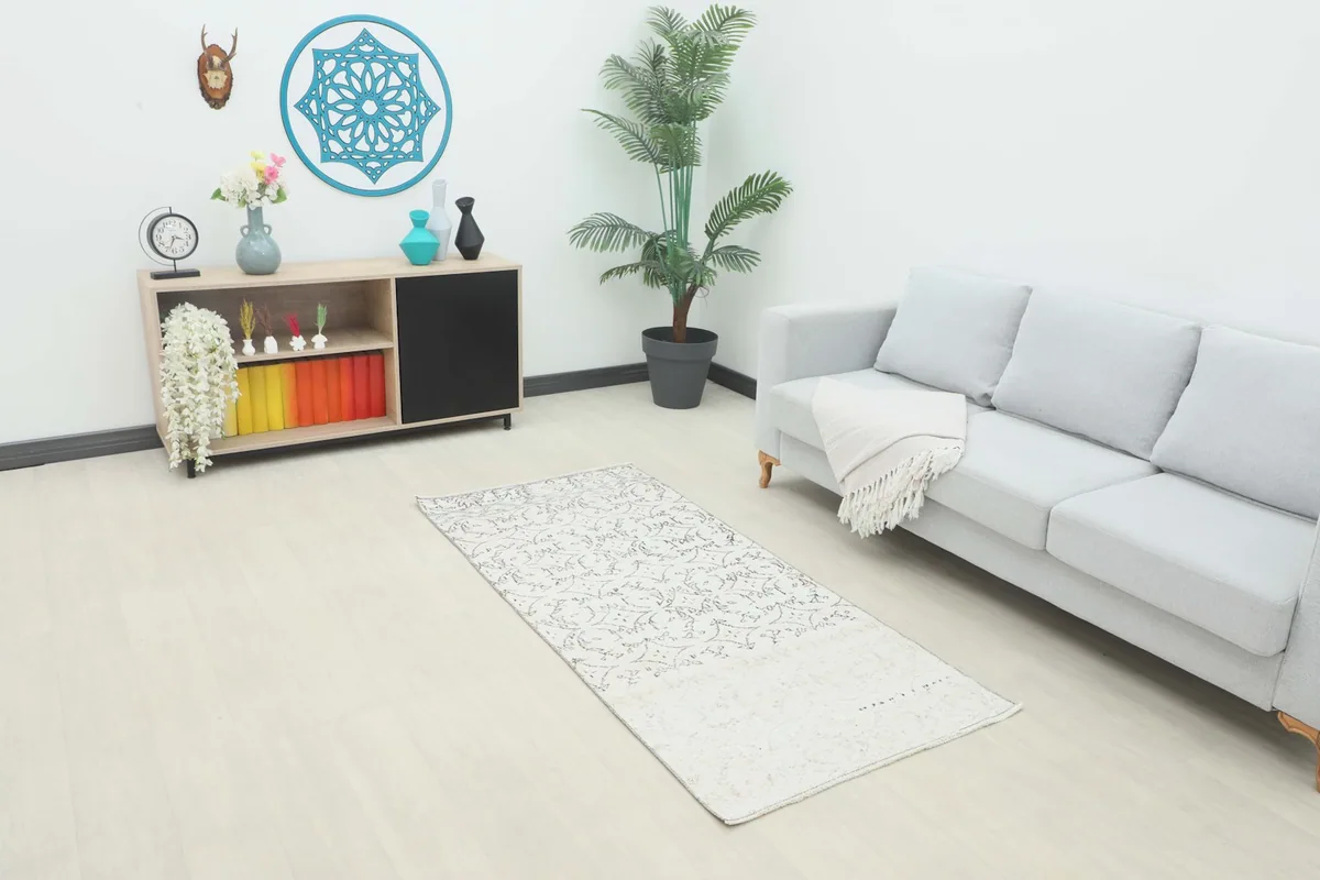 Vintage Anatolian runner placed in a modern living room setting, showing its scale next to a sofa.