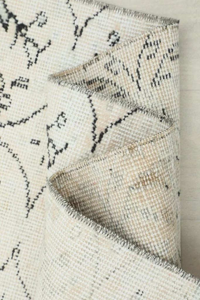 Close-up of the rug's edge and a fold, emphasizing the texture and construction.