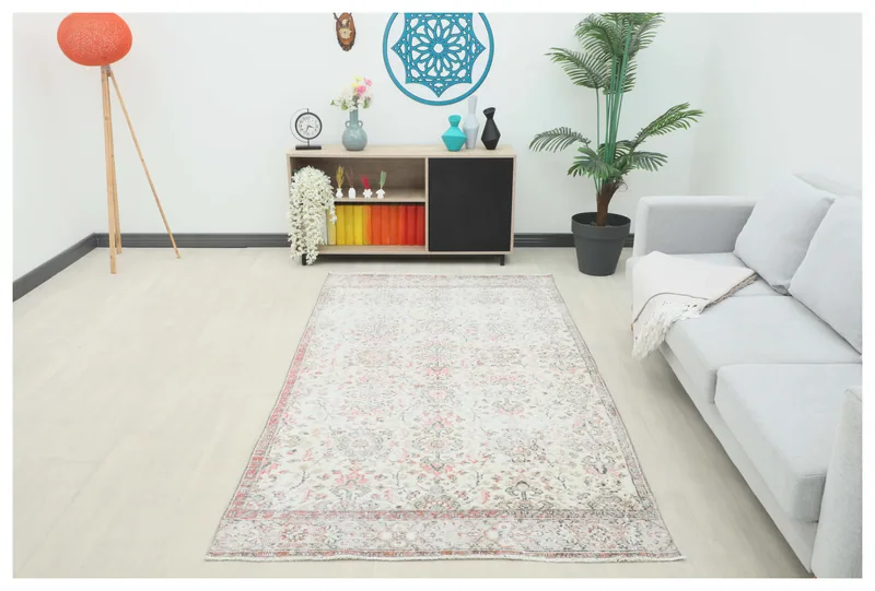 Full overhead view of the ivory and rose floral vintage Anatolian rug on a white background.