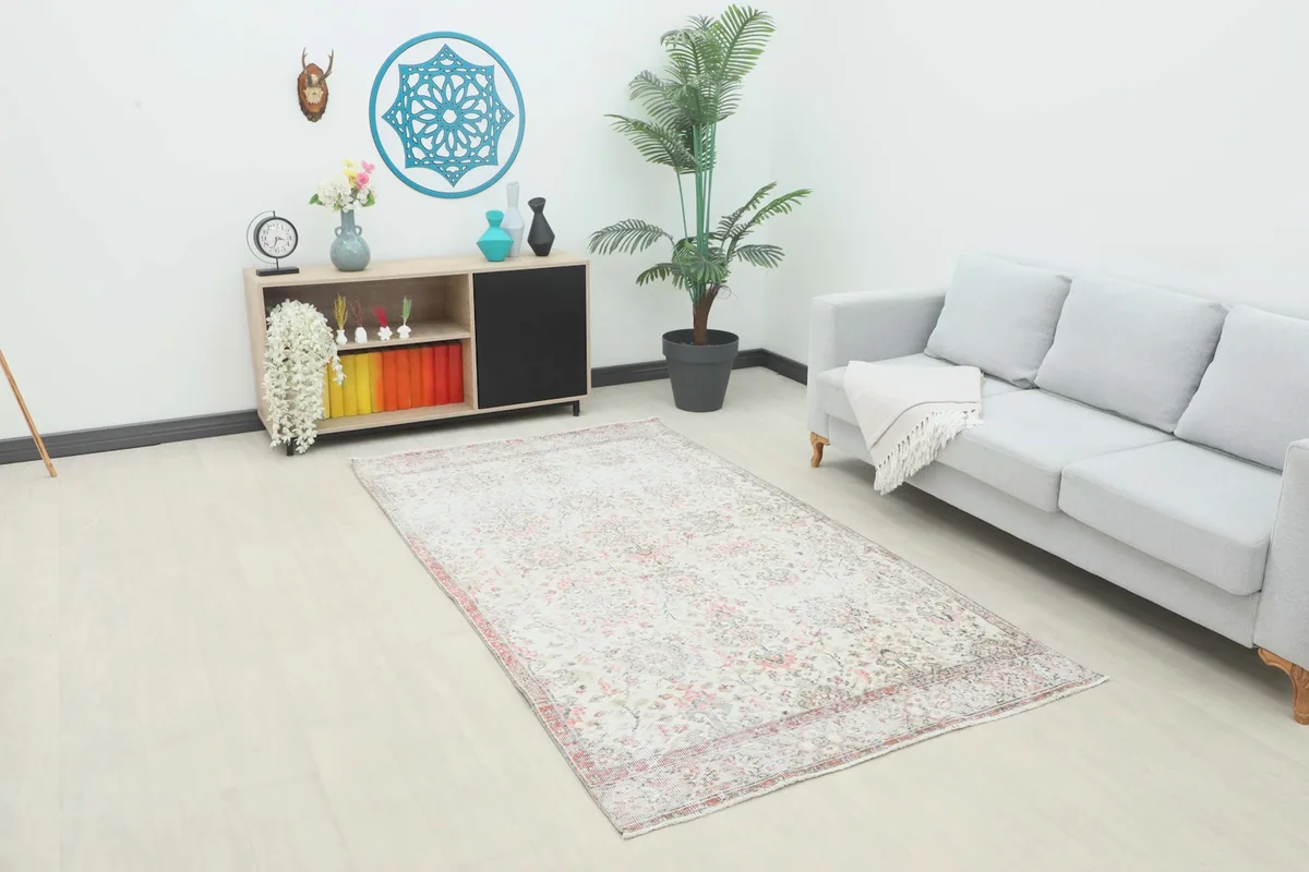 Vintage Anatolian rug displayed in a bright room with modern furniture, showing its overall size and color.