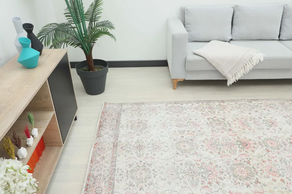 Angled view of the rug in a living space, showcasing its placement next to a sofa and cabinet.