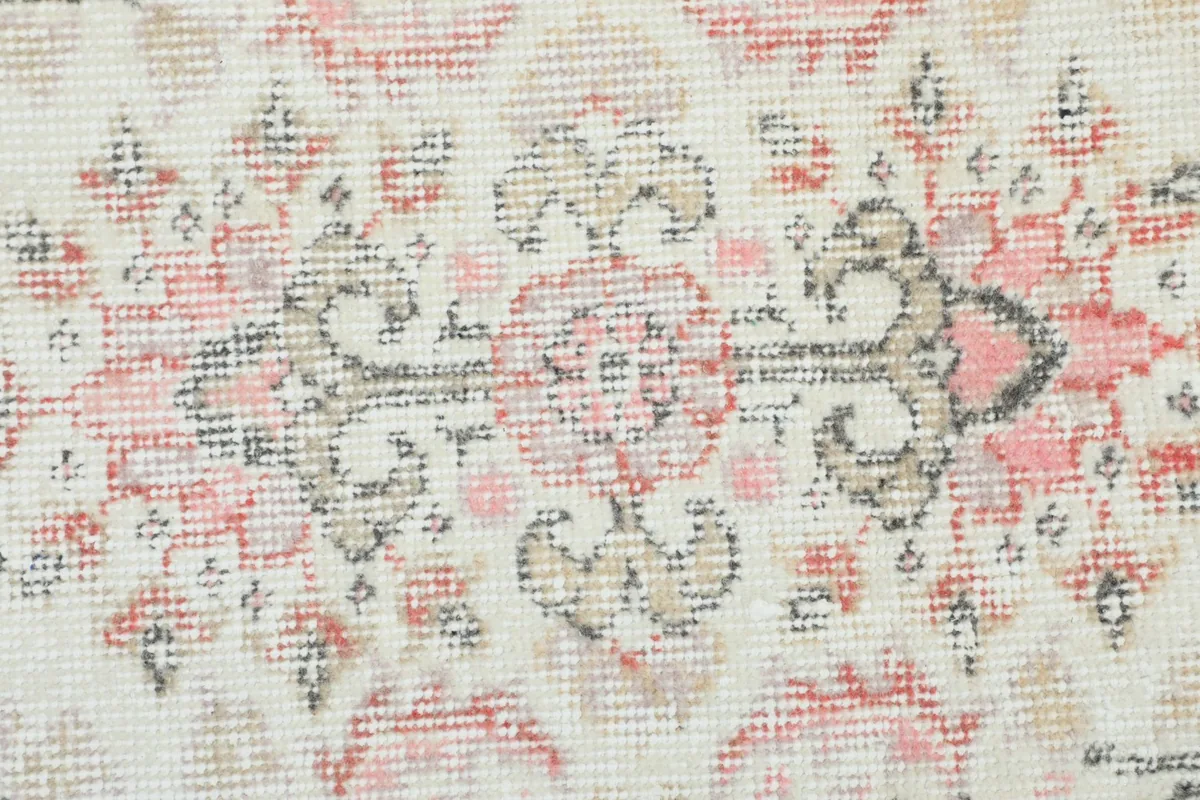Close-up of the rug's surface, showing the faded rose and gray patterns and the low pile texture.