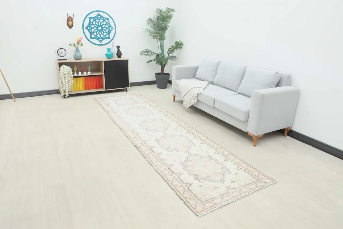 Vintage runner rug in an entryway setting next to a sofa and cabinet