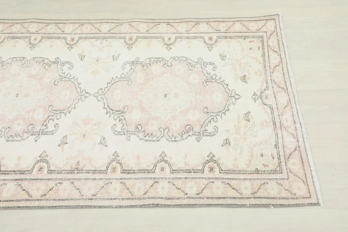 Close-up of a rose medallion motif and geometric border on the vintage runner