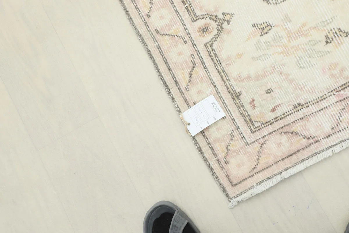 Corner of the rug with a size tag, providing context for scale