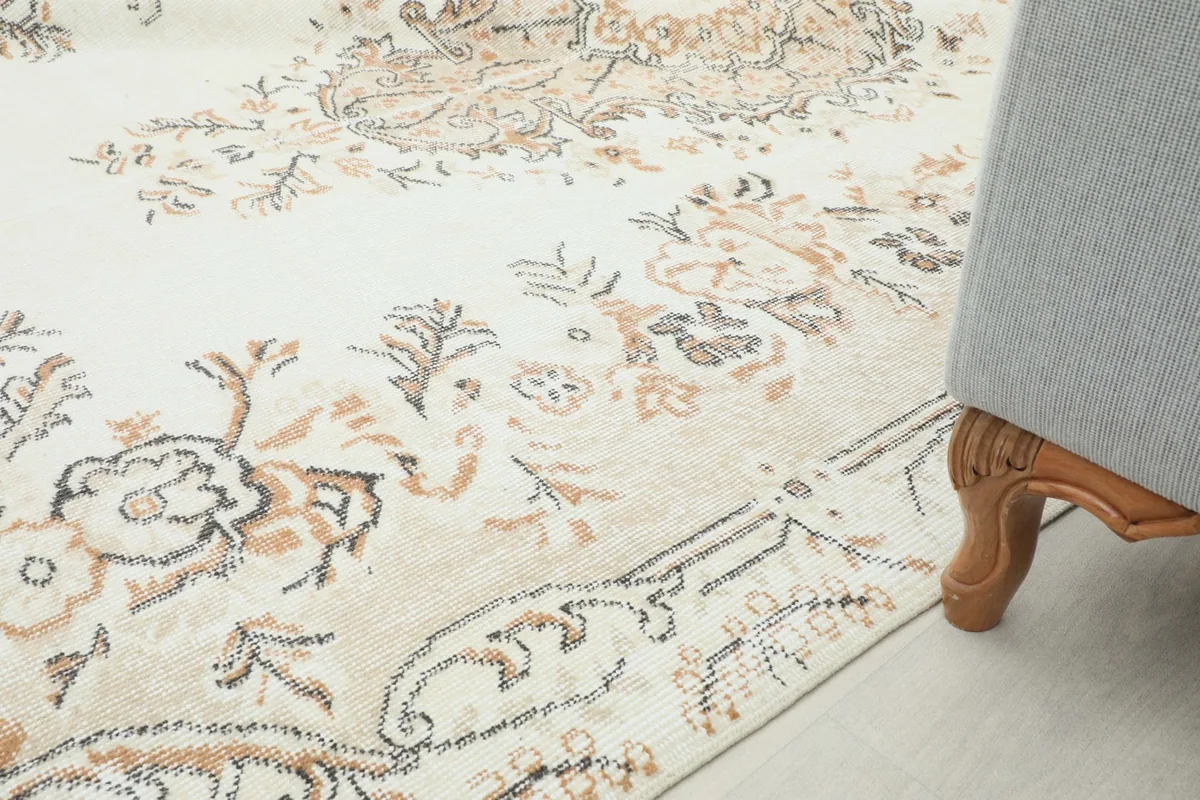 Rug placed next to a sofa leg, demonstrating its size and how it complements furniture