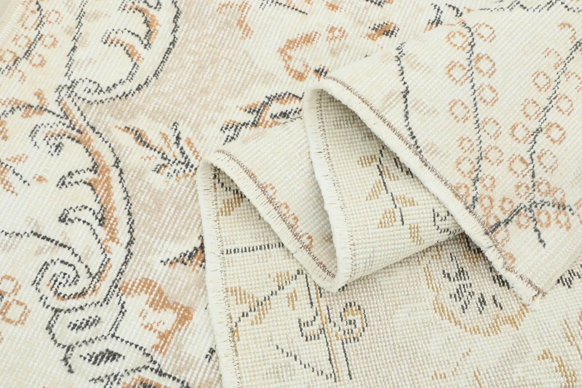 Multiple folds of the rug, showcasing the softness of the low pile and design details