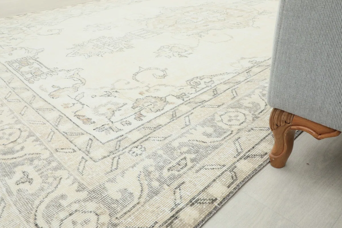 Corner of the rug beside a sofa, highlighting the border design and overall room integration.