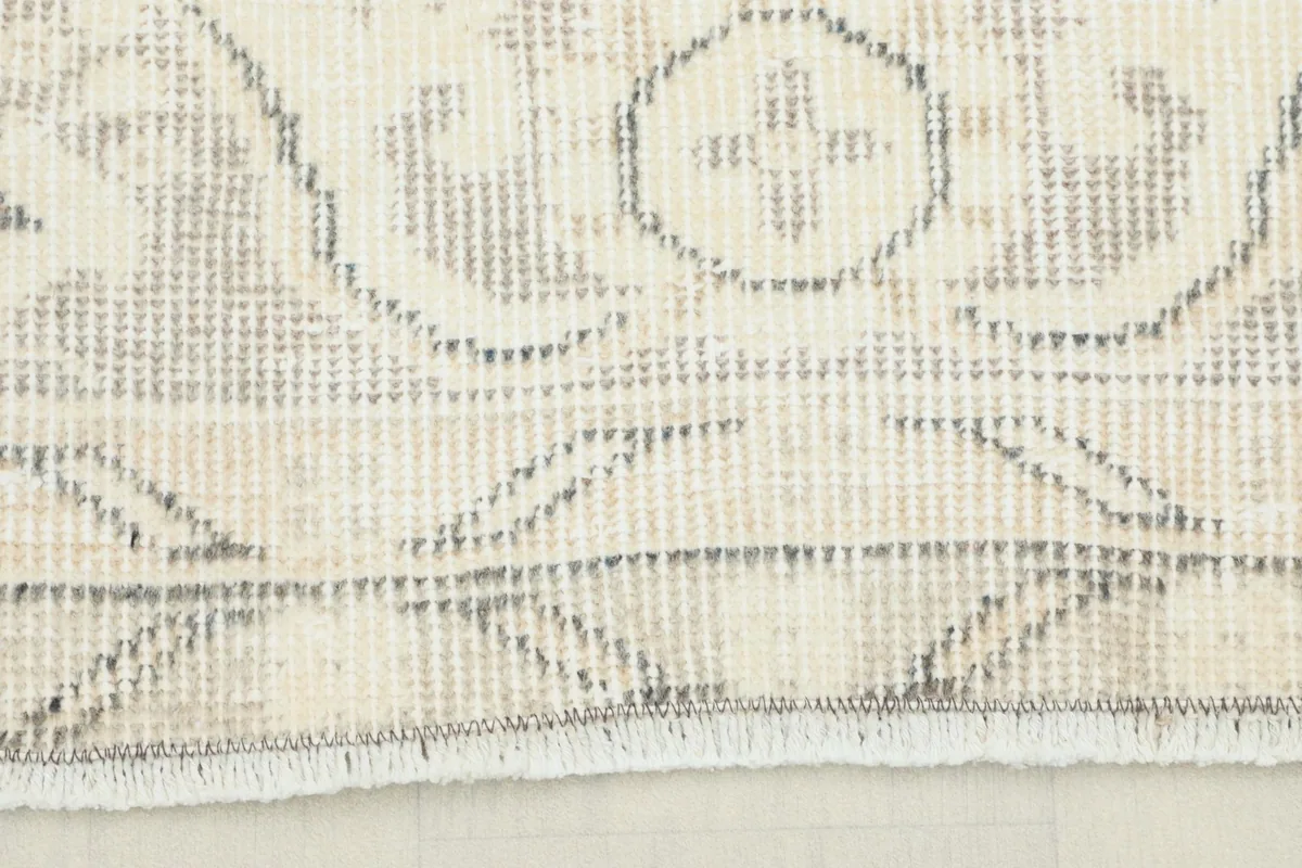 Close-up detail of the hand-knotted pile and geometric patterns on the border of the rug.