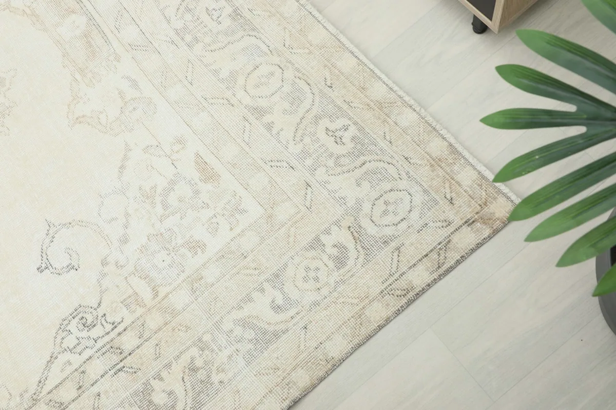 Overhead detail of the beige and gray patterned border and corner of the Anatolian rug.
