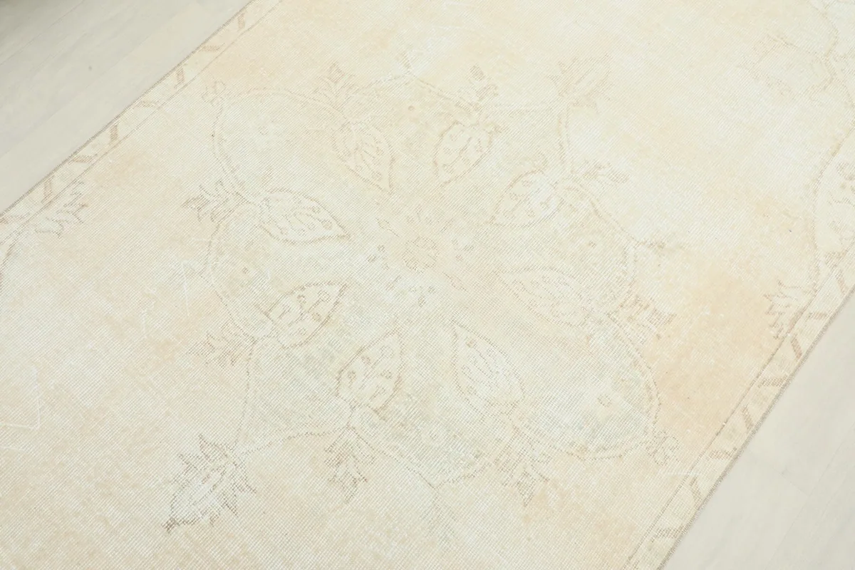 Detailed view of the central medallion and faint floral patterns on the rug